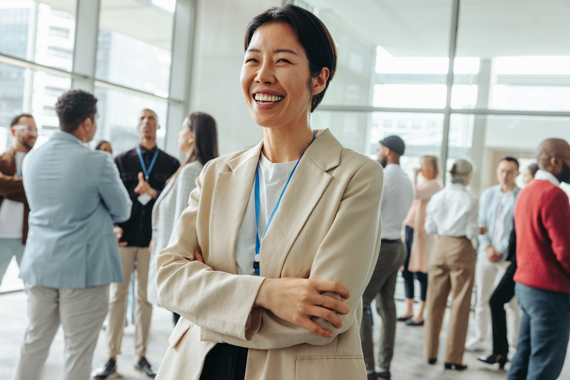 Smiling businesswoman enjoying networking at a conference. Diverse professionals engaged in conversations in a modern conference setting.